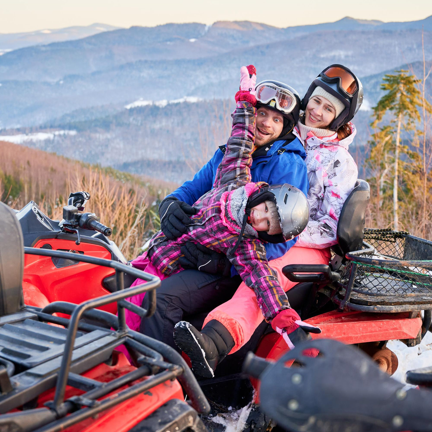 happy-family-of-three-spending-great-time-together-in-the-mountains-in-winter-riding-quad-bike